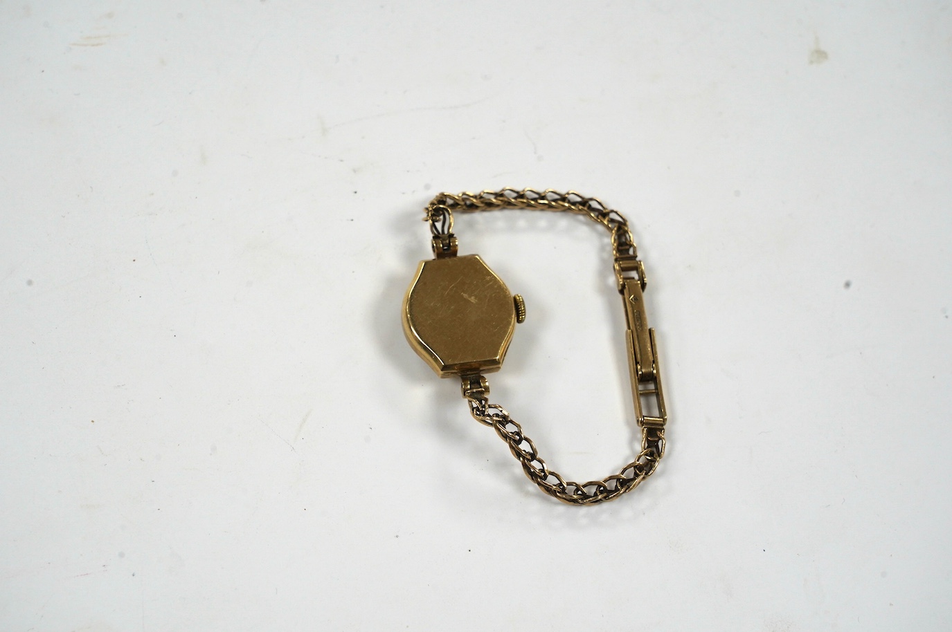 A lady's 9ct gold Omega manual wind wrist watch, on an associated 9ct bracelet, gross weight 12.8 grams. Condition - poor to fair